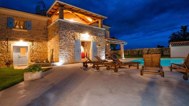 A stone building with a pool, outdoor seating, and a covered patio area. - Stunning home in Bale (Bale)