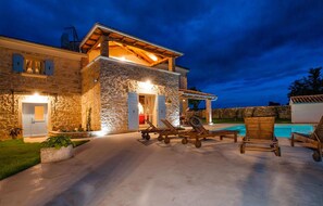 A stone building with a pool, outdoor seating, and a covered patio area. - Stunning home in Bale (Bale)