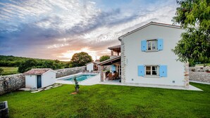 A two-story house with a swimming pool, stone walls, and a well-maintained lawn. - Stunning home in Bale (Bale)