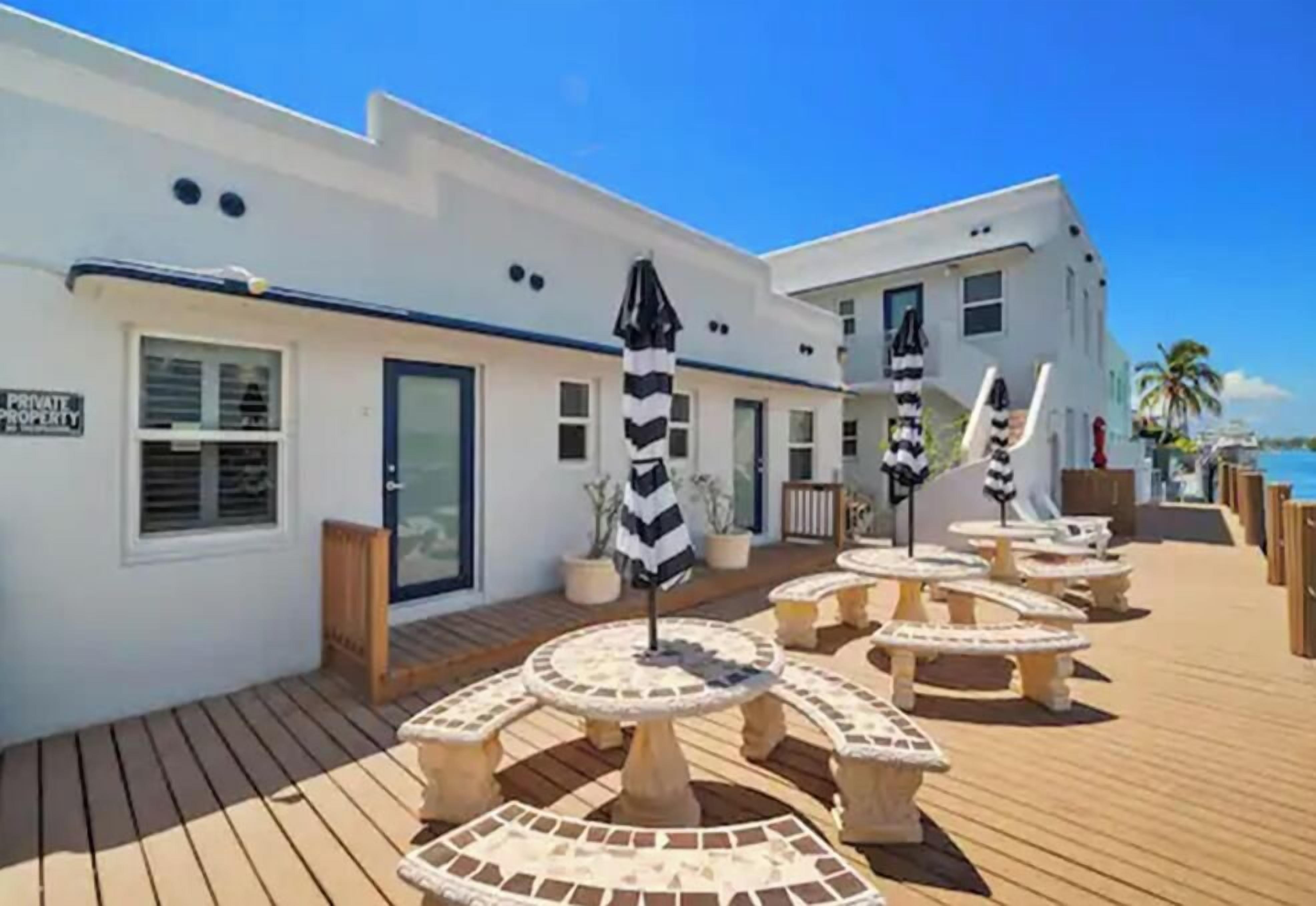 A hotel with a wooden deck, outdoor seating, and a sign indicating private property.