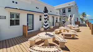Un hotel con terraza de madera, mobiliario exterior y un letrero que indica propiedad privada.