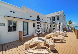 A hotel with a wooden deck, outdoor seating, and a sign indicating private property.