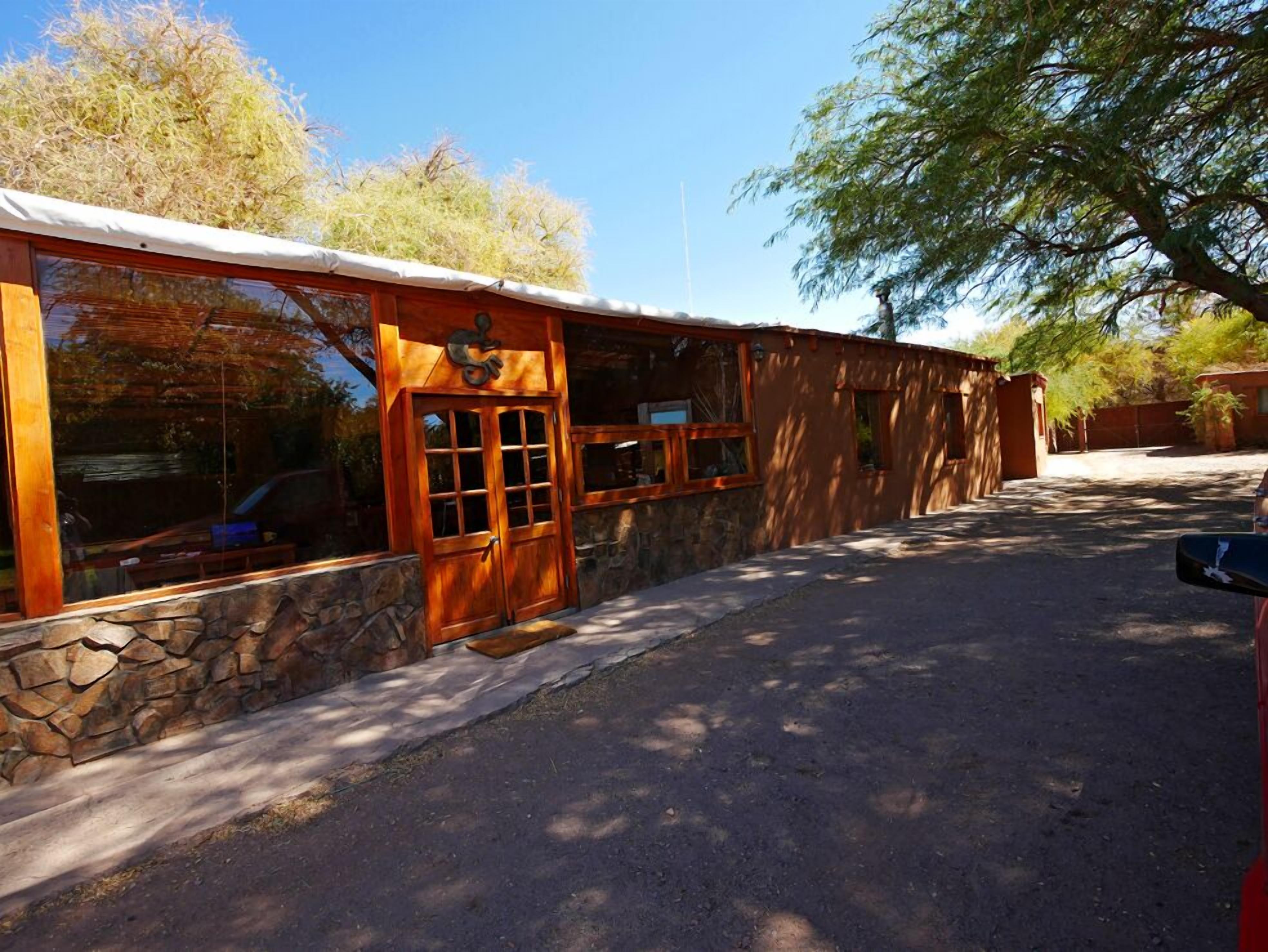 A building with a stone foundation, wooden exterior, and large windows.