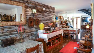 Un comedor con pared de piedra, mobiliario de madera y alfombra roja.