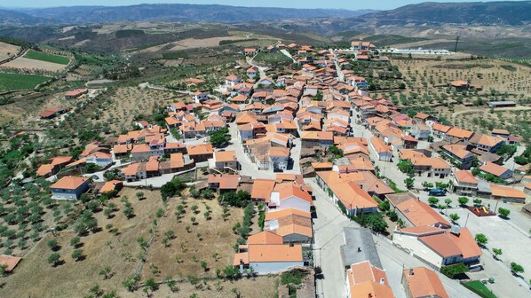 An aerial view of a village with closely packed houses, narrow streets, and surrounding agricultural fields. - PH in Alto Douro Vinhateiro (Torre de Moncorvo)