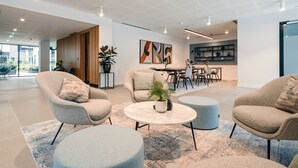A modern living room with a sofa, armchairs, a coffee table, and a dining area with chairs and a table. - City Apartments by Dublin At Home (Dublin)