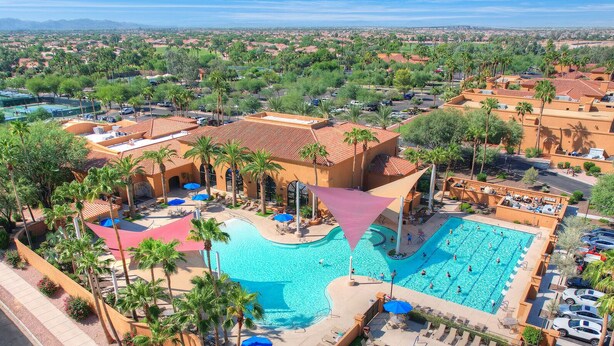 Un complexe hôtelier doté de plusieurs piscines, de palmiers et offrant une vue sur le paysage environnant.