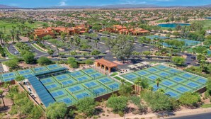 Vue aérienne d’un complexe hôtelier doté de plusieurs courts de tennis, d’un parcours de golf et d’une grande piscine.