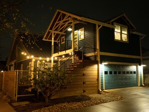 A two-story house with a front porch, a staircase, and a garage. - Gorgeous, one-bedroom garage apartment in a quiet neighborhood (Austin)