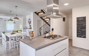 A modern kitchen with a central island, stainless steel appliances, and a chalkboard with a recipe. - Amazing home in Krnica (Krnica)