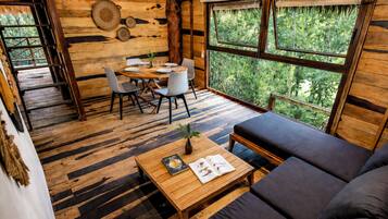 Exclusive-Baumhaus, Mehrere Betten, Terrasse, Zwischengeschoss | Wohnbereich | Bücher