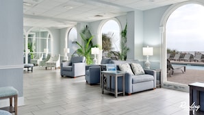 A spacious lobby with a pool view, modern furniture, and large windows. - ⛱ FABULOUS DIRECT OCEANFRONT KING BED⛱ ALL NEW RENOVATION! BALCONY! POOL VIEW ! (Myrtle Beach)