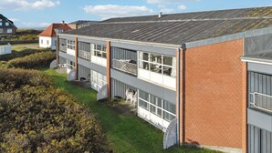 Un edificio de varios pisos con fachada de ladrillo, ventanas grandes y techo plano.