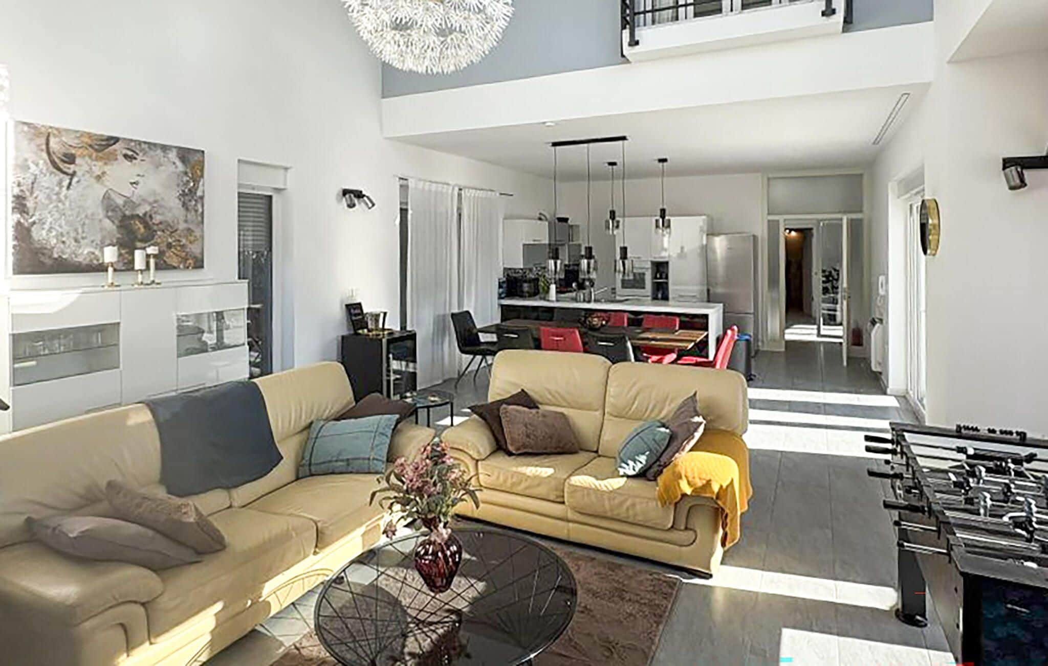 Uma sala de estar moderna com um sofá, mesa de centro e um quadro na parede.