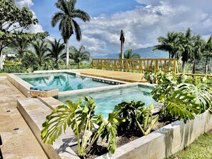 Relax by the serene pool surrounded by lush tropical vegetation and picturesque mountain views.