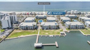 A coastal hotel with multiple buildings, a dock, and a clear view of the beach. - Family waterfront condo,Dog Friendly, pools, boat launch, beach access, WIFI! (Gulf Shores)