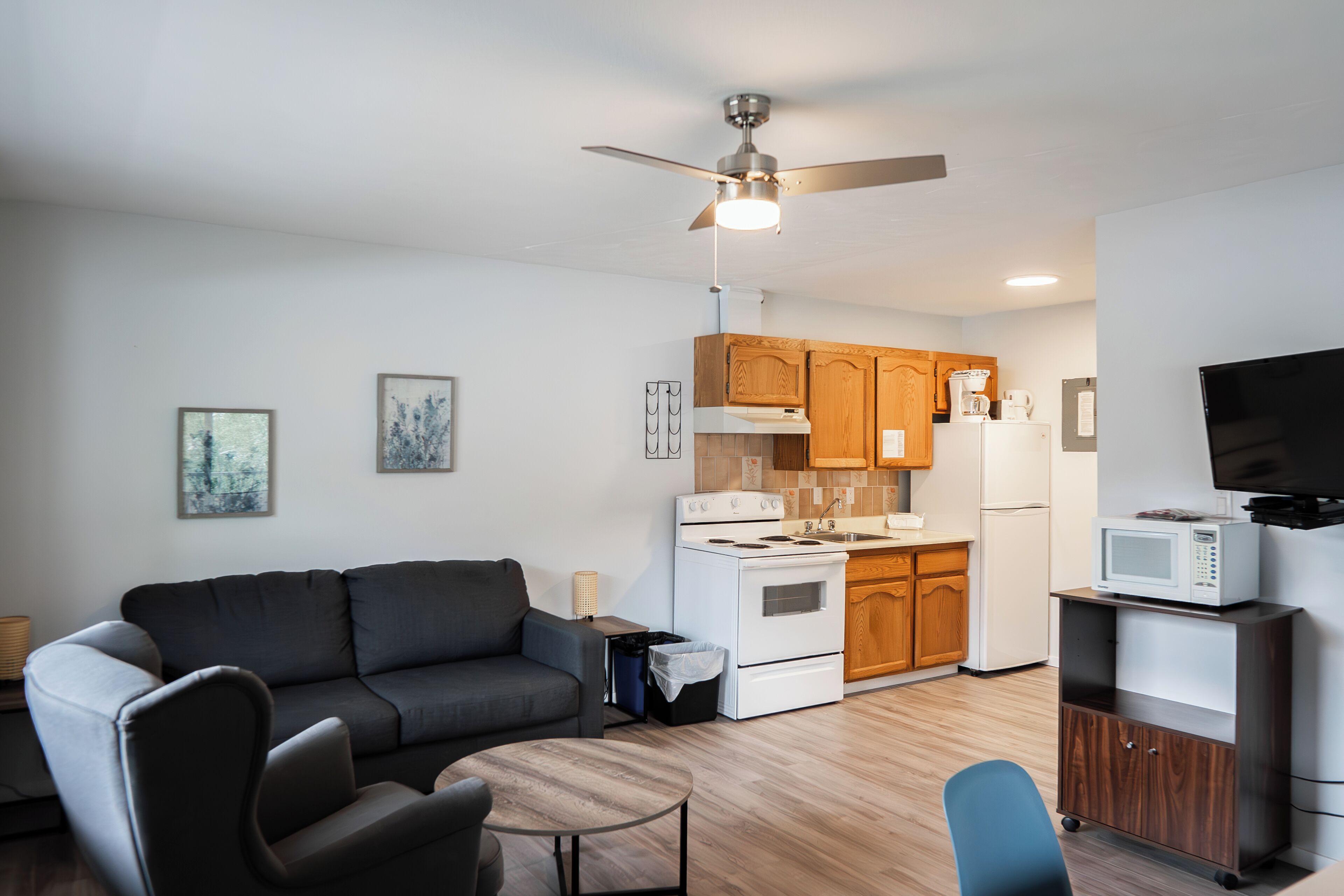 Un apartamento moderno con sala de estar, cocina y televisor de pantalla plana.