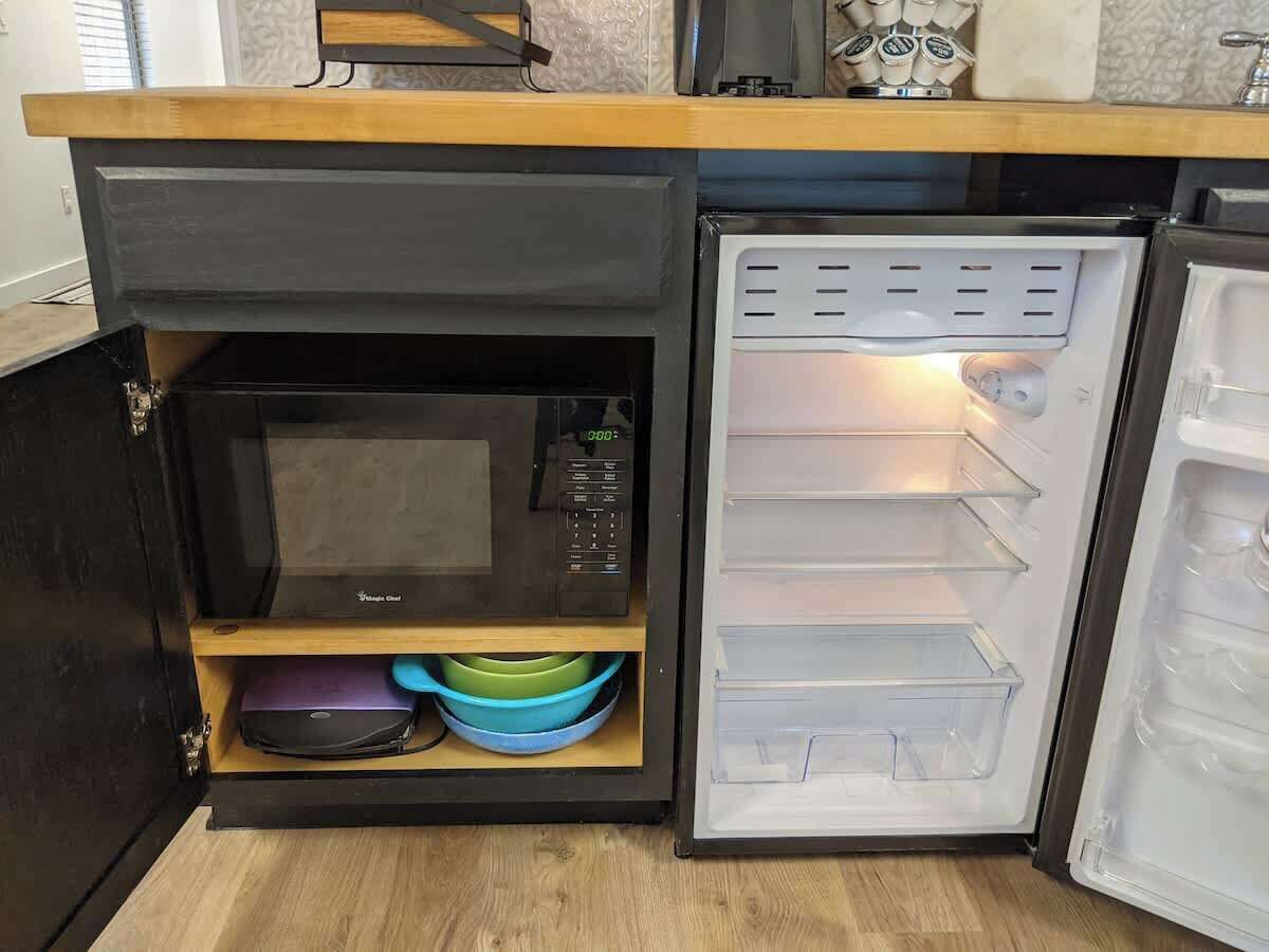 A compact kitchen with a microwave, a built-in oven, and a refrigerator.