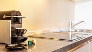 A modern kitchen with a coffee machine, a cup, and a spoon on the counter. - Apartment 'Alagundis  Pyropus Familia' with Mountain View, Shared Pool and Wi-Fi (Lagundo)