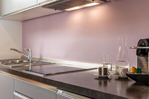 Une cuisine moderne équipée d’appareils électroménagers en acier inoxydable, d’une machine à café et d’un distributeur d’eau.