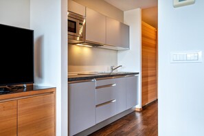Eine moderne Küche mit eingebauter Mikrowelle, einer Spüle und Holzschränken.
