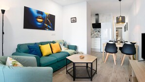 Ein modernes Wohnzimmer mit einer Couch, einem Couchtisch und einem Essbereich mit Stühlen und einem Tisch.