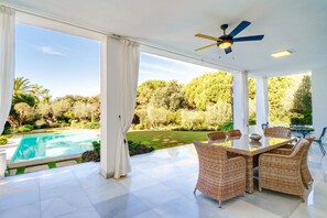 A covered outdoor area with a pool, wicker furniture, and a ceiling fan. - Villa 'Hacienda Las Chapas' with Private Pool, Wi-Fi and Air Conditioning (Marbella)
