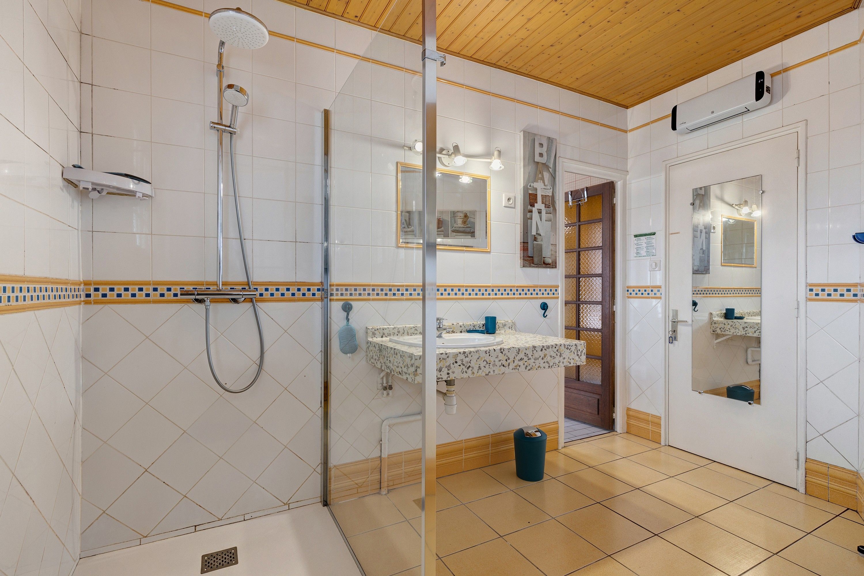 A bathroom with a shower, a sink, and a mirror.