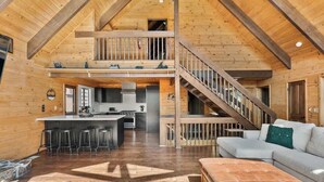 Een ruime loft met een keuken, eethoek en een trap naar een hoger niveau.
