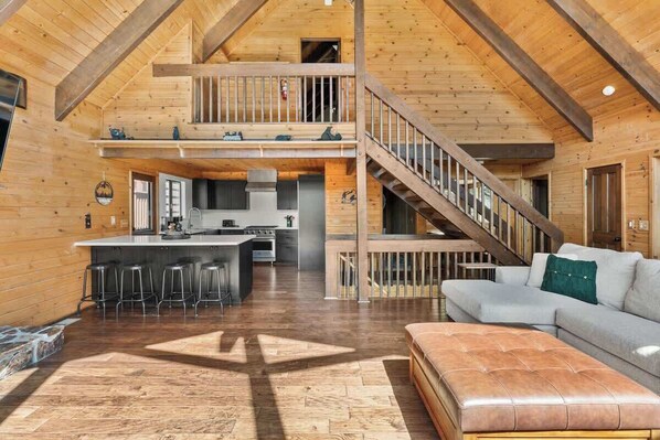 Un loft amplio con cocina, comedor y una escalera que sube a un nivel superior.