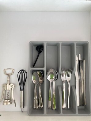 Un cajón de cocina con utensilios organizados en compartimentos.