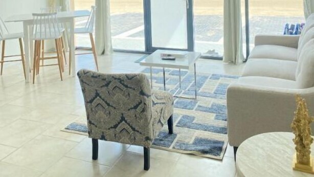 A spacious living area with a dining table, two sofas, and a patterned armchair. - Bushiri's Long Life Building-2BD/1BA APT-Sleeps 4 (Oranjestad)