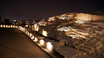 Una extensa y luminosa ciudad antigua con estructuras escalonadas y un río.
