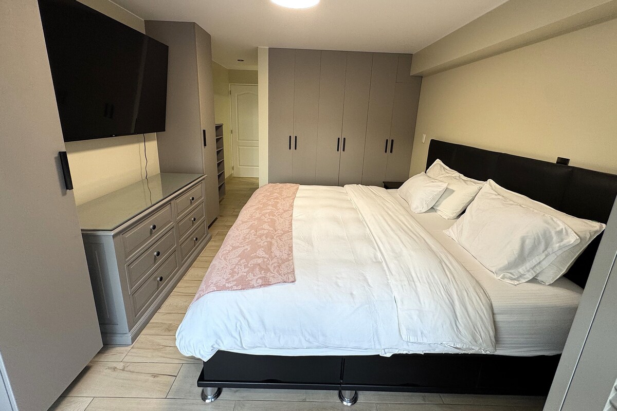Une chambre à coucher avec un lit, une télévision et des placards intégrés.