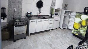 A compact kitchen with a gas stove, oven, and a refrigerator.