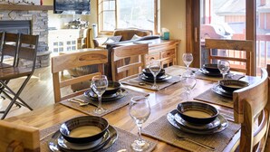 A dining area with a wooden table set for four, including plates, glasses, and cutlery.