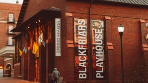 Tiilestä rakennettu rakennus, jonka yläpuolella on kyltti, jossa lukee: ”BLACKFRIARS PLAYHOUSE” ja ”KEVÄTKAUDEKSI”.