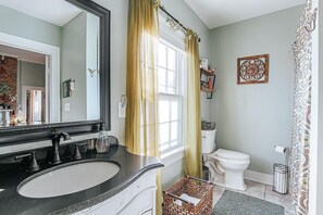 A bathroom with a sink, toilet, and shower curtain. - The Bohemian Suite: King Bed, Walk Downtown (Staunton)