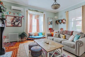 Una sala de estar acogedora con un sofá, una mesita de centro y un ventanal con cortinas.