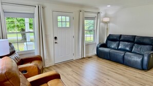A living room with a brown leather sofa, a blue leather couch, and a wooden floor. - Farmhouse in Livingston  (Livingston)