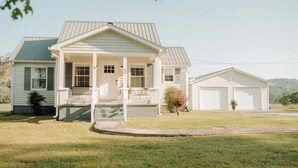 A two-story house with a front porch, a garage, and a well-maintained lawn. - Farmhouse in Livingston  (Livingston)