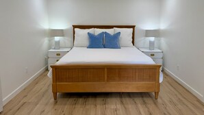 A bedroom with a wooden bed, white walls, and two bedside tables with lamps. - Farmhouse in Livingston  (Livingston)