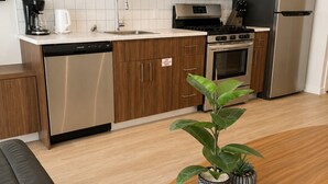 A modern kitchen with a dishwasher, stove, microwave, and refrigerator. - One Bedroom Suite in Downtown Sidney (Sidney)
