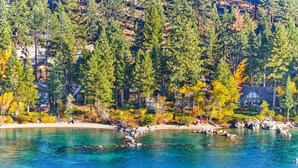 Una propietat costanera amb diverses cabanes envoltades per un bosc dens i aigua turquesa.
