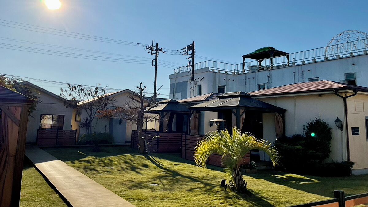Um bairro residencial com casas, um pequeno jardim e céu claro.
