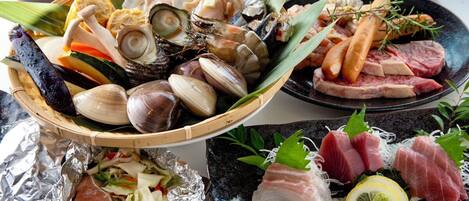 A variety of seafood including clams, shrimp, and fish, arranged on plates and in a basket.