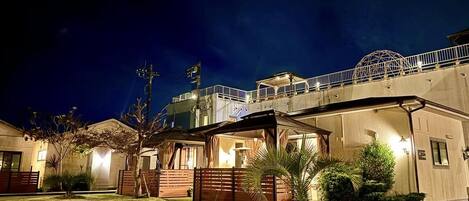 A hotel with a covered outdoor area, a bridge, and a well-lit entrance.