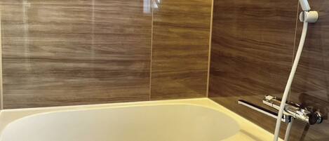 Une salle de bain moderne équipée d’une baignoire, d’une douche et d’un porte-serviettes.
