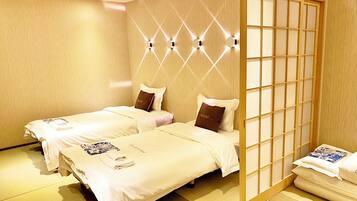 Une chambre d’hôtel avec deux lits, chacun étant équipé d’un oreiller et d’une serviette pliée.