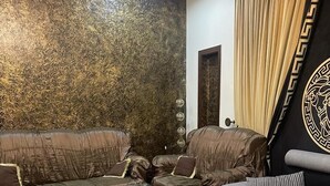 Una sala moderna con pared decorativa, una mesa de centro de vidrio y un conjunto de sofá.